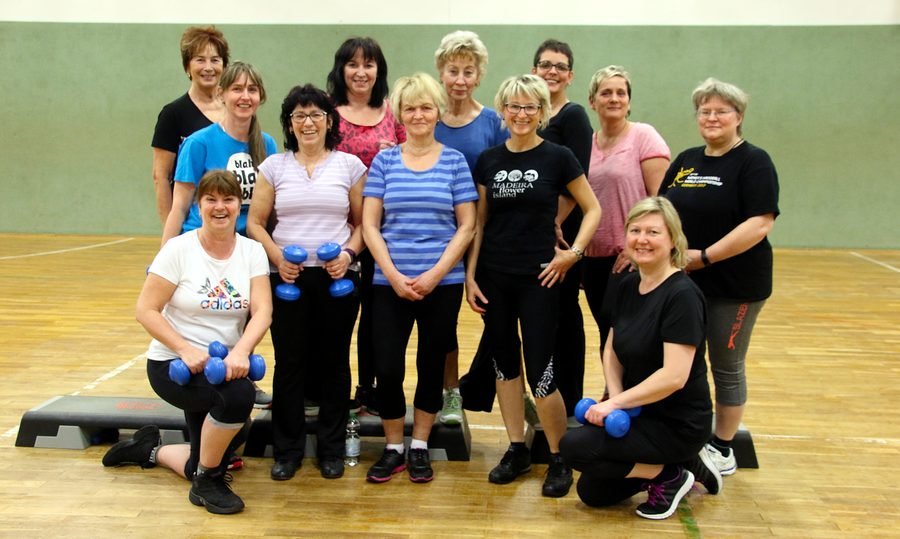 Die Step-Aerobic-Gruppe mit Hanteln und Stepbrettern.